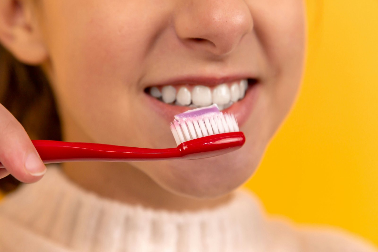 A person brushing teeth with a soft toothbrush