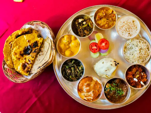 An Indian thali with dal, sabzi, rice, raita and rotis